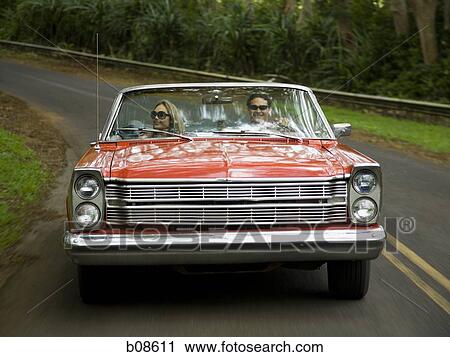 Young couple in a convertible car View Large Photo Image Stock Image - Young couple in a convertible car. Fotosearch
