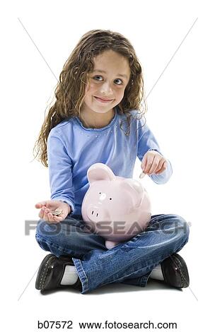 Young girl depositing money in piggy bank View Large Photo Image Stock Image - Young girl depositing money in piggy bank. Fotosearch
