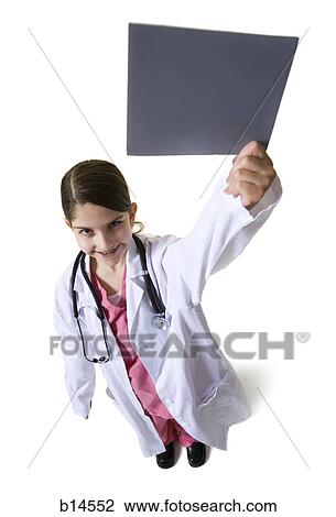 Young girl dressed as doctor with white coat and stethoscope holding blank sign View Large Photo Image Stock Image - Young girl dressed as doctor with white coat and stethoscope holding blank sign. Fotosearch