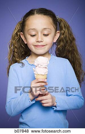 Young girl holding cone with two scoops of ice cream View Large Photo Image Stock Photo - Young girl holding cone with two scoops of ice cream. Fotosearch