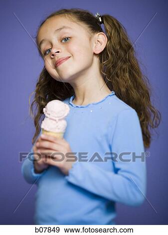Stock Photo - Young girl holding cone with two scoops of ice cream. Fotosearch