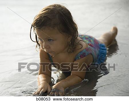 Young girl playing in shallow surf on beach View Large Photo Image Stock Image - Young girl playing in shallow surf on beach. Fotosearch
