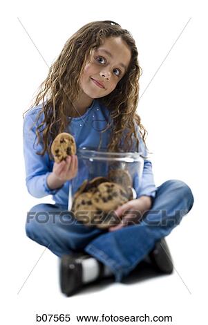 Stock Photography - Young girl taking cookie from cookie jar. Fotosearch