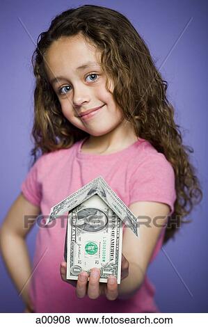 Young girl with a little house made of banknotes View Large Photo Image Stock Photo - Young girl with a little house made of banknotes. Fotosearch