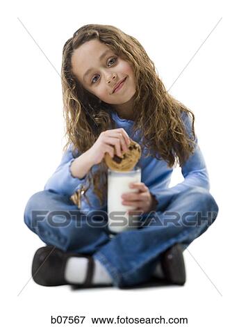Young girl with cookie and a glass of milk View Large Photo Image Stock Photo - Young girl with cookie and a glass of milk. Fotosearch