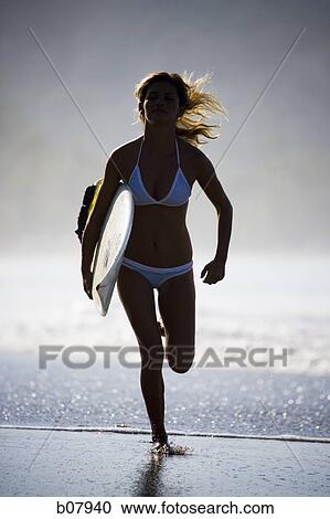 Young woman with surfboard on beach View Large Photo Image Stock Image - Young woman with surfboard on beach. Fotosearch