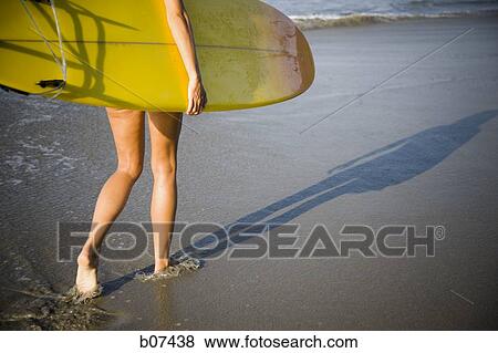 Young woman with surfboard on beach View Large Photo Image Stock Photo - Young woman with surfboard on beach. Fotosearch