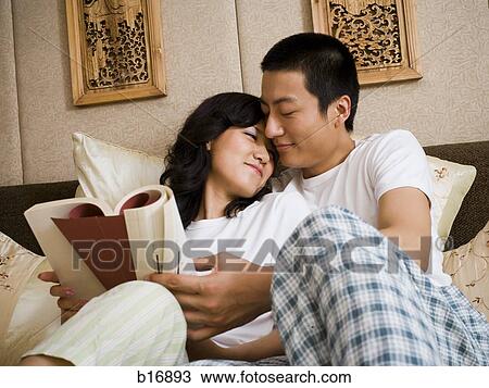 床に就いているカップル 寄り添う そして 読書 ストックイメージ B163 Fotosearch