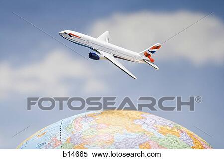 Stock Photography - Airplane flying over globe with blue sky. Fotosearch