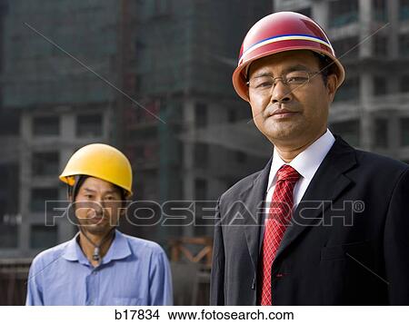 Architect on the job site with a worker. View Large Photo Image Picture - Architect on the job site with a worker.. Fotosearch