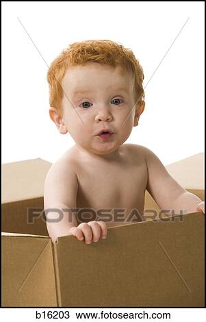 Baby boy in cardboard box making funny face View Large Photo Image Stock Image - Baby boy in cardboard box making funny face. Fotosearch