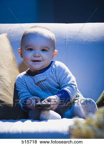 Baby on sofa with television remote smiling View Large Photo Image Stock Photo - Baby on sofa with television remote smiling. Fotosearch