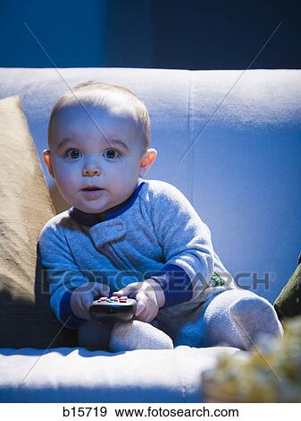 Baby on sofa with television remote View Large Photo Image Stock Photo - Baby on sofa with television remote. Fotosearch
