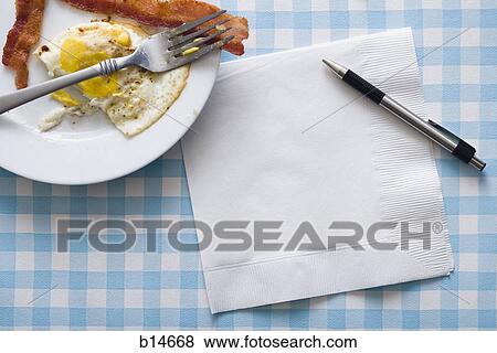 Bacon and eggs with fork napkin and pen View Large Photo Image Stock Photo - Bacon and eggs with fork napkin and pen. Fotosearch