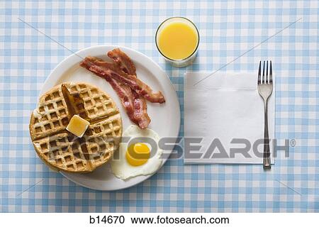 Bacon and eggs with waffle and orange juice with napkin and fork View Large Photo Image Stock Image - Bacon and eggs with waffle and orange juice with napkin and fork. Fotosearch