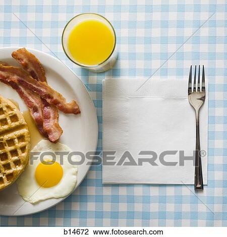 Bacon and eggs with waffle and orange juice with napkin and fork View Large Photo Image Stock Image - Bacon and eggs with waffle and orange juice with napkin and fork. Fotosearch