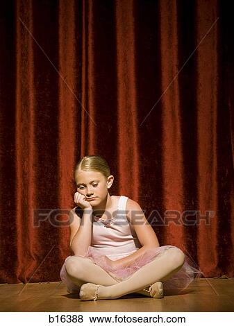 Stock Photo - Ballerina girl sitting on stage sulking. Fotosearch