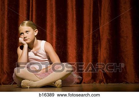 Stock Photo - Ballerina girl sitting on stage sulking. Fotosearch