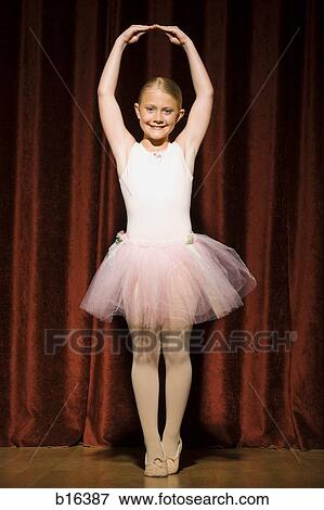 Ballerina girl standing with arms over head smiling View Large Photo Image Stock Photo - Ballerina girl standing with arms over head smiling. Fotosearch