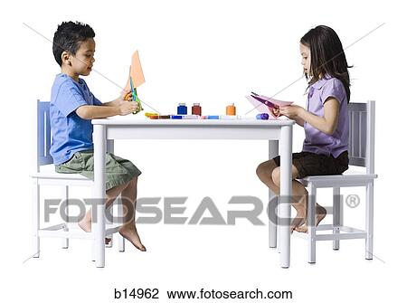 Boy and girl sitting at table doing crafts View Large Photo Image Stock Image - Boy and girl sitting at table doing crafts. Fotosearch