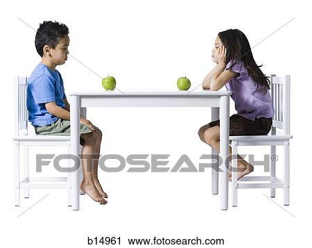 Boy and girl sitting at table with green apples View Large Photo Image Stock Image - Boy and girl sitting at table with green apples. Fotosearch