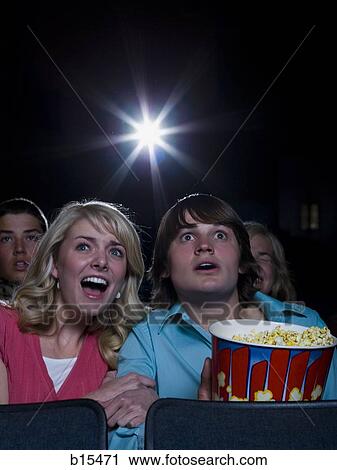 Boy and girl with popcorn frightened at movie theater View Large Photo Image Stock Image - Boy and girl with popcorn frightened at movie theater. Fotosearch