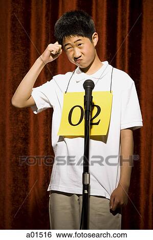 Boy at microphone with number around neck scratching head View Large Photo Image Stock Photograph - Boy at microphone with number around neck scratching head. Fotosearch