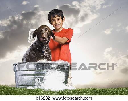 Boy bathing dog outdoors on cloudy day View Large Photo Image Stock Image - Boy bathing dog outdoors on cloudy day. Fotosearch