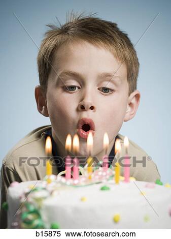 Stock Photography - Boy blowing out candles on a birthday cake. Fotosearch