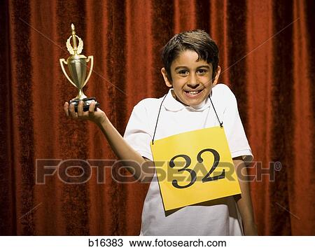 Boy contestant holding trophy View Large Photo Image Stock Image - Boy contestant holding trophy. Fotosearch