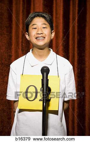 Stock Photo - Boy contestant standing at microphone smiling with braces. Fotosearch
