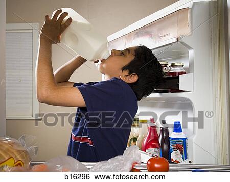 Boy drinking milk from jug in refrigerator View Large Photo Image Stock Photograph - Boy drinking milk from jug in refrigerator. Fotosearch