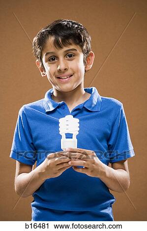 Boy holding energy efficient lightbulb smiling View Large Photo Image Stock Image - Boy holding energy efficient lightbulb smiling. Fotosearch