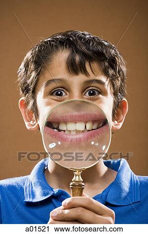 Boy holding magnifying glass to mouth smiling View Large Photo Image Stock Image - Boy holding magnifying glass to mouth smiling. Fotosearch