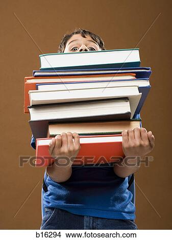 Boy holding pile of textbooks View Large Photo Image Picture - Boy holding pile of textbooks. Fotosearch