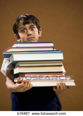 Boy holding pile of textbooks View Large Photo Image Stock Photo - Boy holding pile of textbooks. Fotosearch
