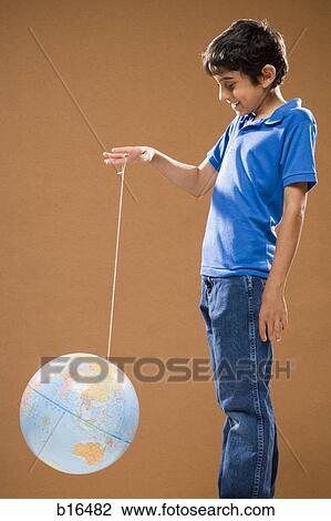 Boy holding string with globe attached smiling View Large Photo Image Stock Image - Boy holding string with globe attached smiling. Fotosearch