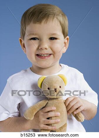 Stock Image - Boy holding teddy bear smiling. Fotosearch