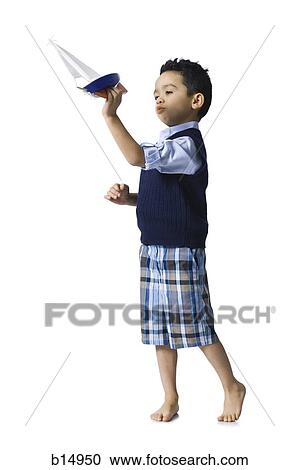 Stock Image - Boy holding toy boat. Fotosearch