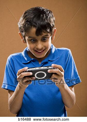 Stock Photo - Boy holding video game smiling. Fotosearch
