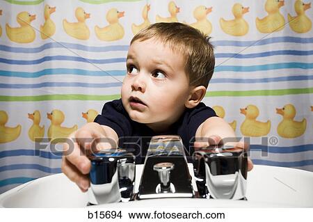 Boy in bathroom at sink View Large Photo Image Picture - Boy in bathroom at sink. Fotosearch