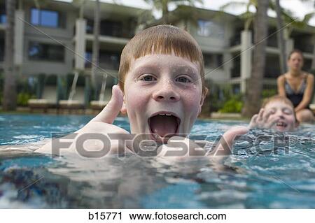 Boy in outdoor pool making funny face with thumbs up View Large Photo Image Stock Image - Boy in outdoor pool making funny face with thumbs up. Fotosearch