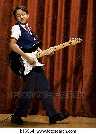 Picture - Boy on stage playing electric guitar. Fotosearch
