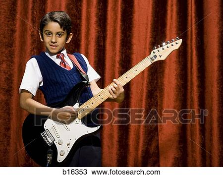 Stock Image - Boy on stage playing electric guitar. Fotosearch