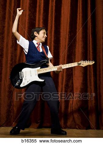 Boy on stage playing electric guitar View Large Photo Image Stock Photography - Boy on stage playing electric guitar. Fotosearch