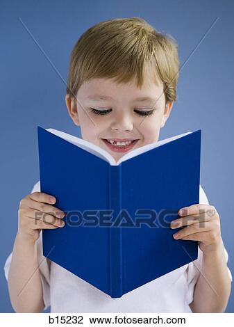 Stock Image - Boy reading book and smiling. Fotosearch