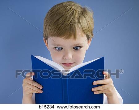 Picture - Boy reading harcover book cross eyed. Fotosearch