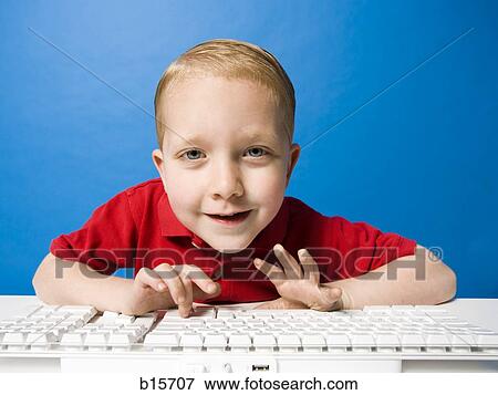 Boy sitting at keyboard smiling View Large Photo Image Stock Photo - Boy sitting at keyboard smiling. Fotosearch