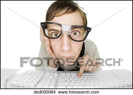 Boy sitting at keyboard with tape on eyeglasses View Large Photo Image Picture - Boy sitting at keyboard with tape on eyeglasses. Fotosearch