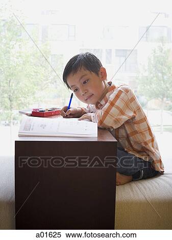 Boy sitting cross legged with school books writing View Large Photo Image Stock Photography - Boy sitting cross legged with school books writing. Fotosearch